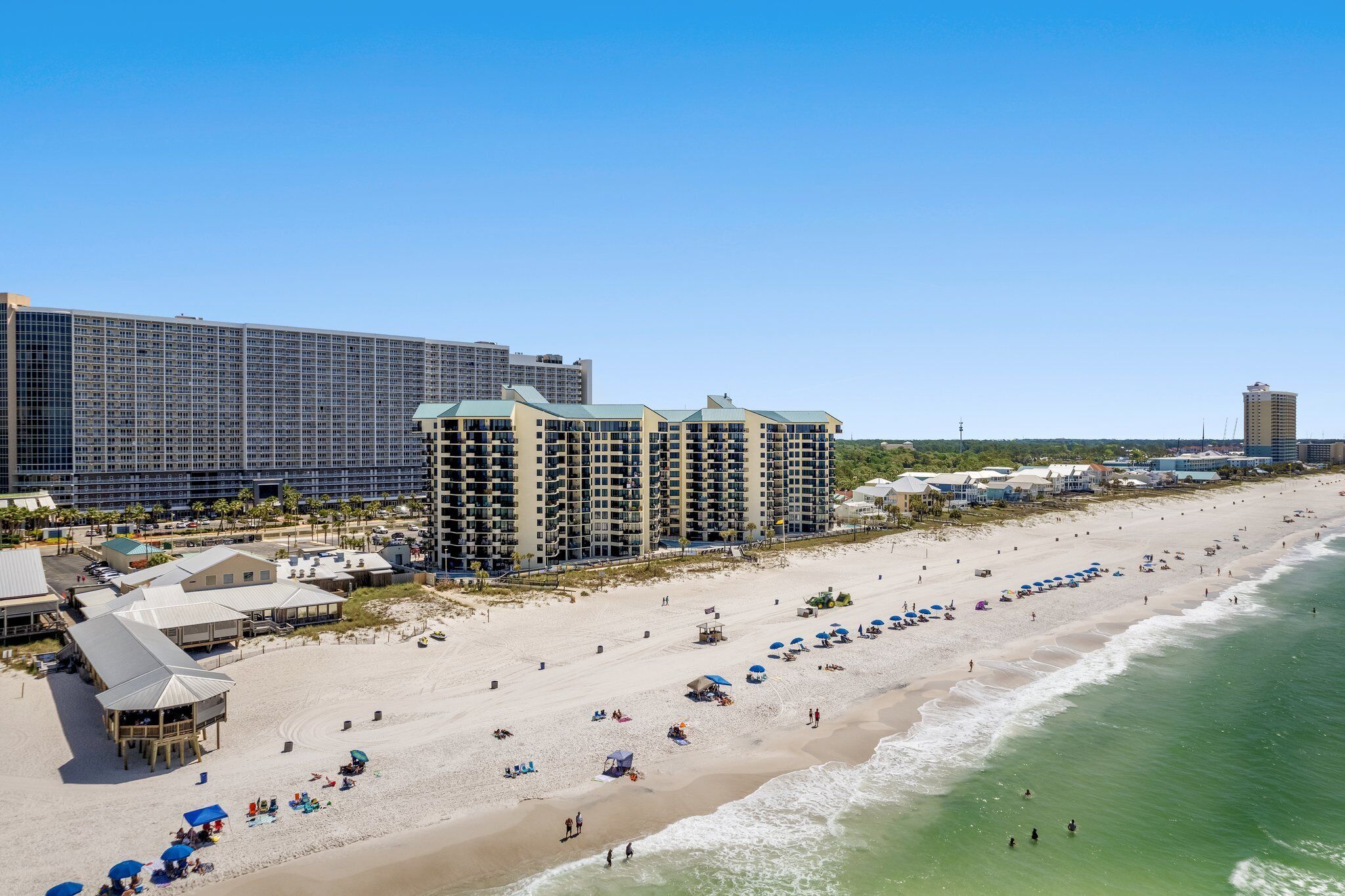 A beachfront hotel with multiple buildings, a sandy beach, and ocean views.