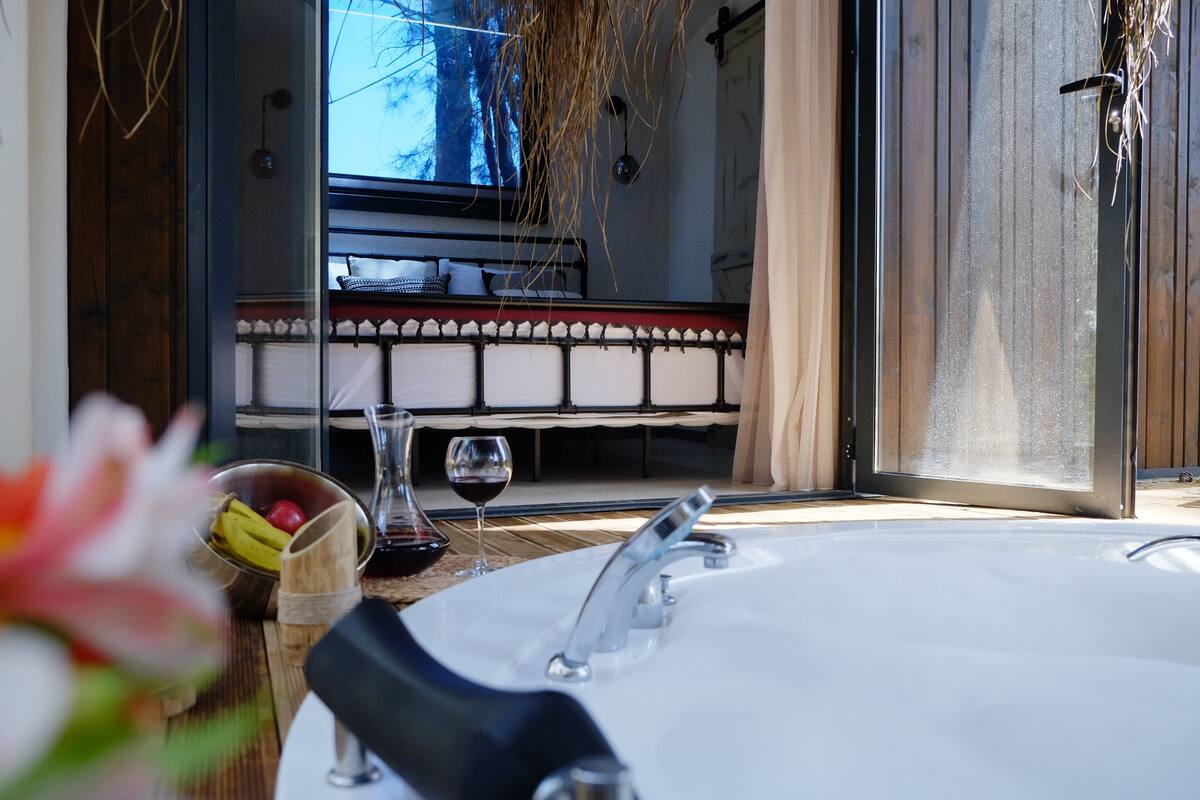 A bathroom with a bathtub, a sink, and a window.