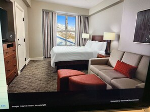 Comfortable room with a large bed, sofa, and television.