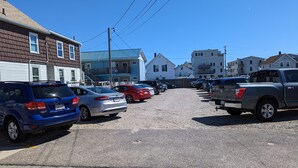 A parking lot with several cars and buildings in the background.