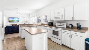 A modern kitchen with white cabinets, a microwave, oven, and a coffee maker. - New Listing! Highgate at Legacy Park Resort, 7mi to Disney & 10mi to Universal - FS370169 (Davenport)