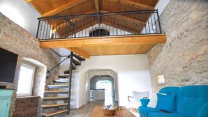 A spacious loft with a wooden staircase, stone walls, and a blue sofa. - Villa Gisella with heated swimming pool (Nedešćina (Istria))