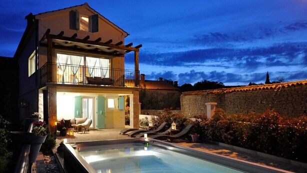 A two-story house with a swimming pool, a balcony, and a stone wall. - Villa Gisella with heated swimming pool (Nedešćina (Istria))