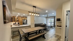 A modern kitchen with a central island, wooden bench seating, and a ceiling fan. - Bright Haus Lakeview at the Village at Breck ,Stunning Views, Ski In/Out In Town (Breckenridge)
