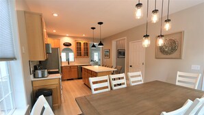Une cuisine moderne avec des meubles en bois, un îlot central et des luminaires suspendus.