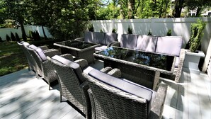 Une terrasse extérieure avec des meubles en osier et une table à plateau en verre.