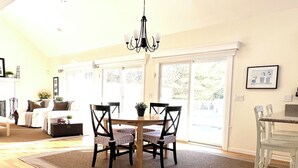 A dining area with a round table, four chairs, and a chandelier. - Pristine Remsenburg Retreat to Play & Work All Summer Long (Remsenburg)