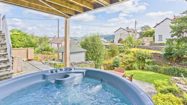Ein Whirlpool unter einer Hollaube mit Blick auf eine Wohngegend.