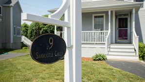 Une maison avec une plaque indiquant « 9, Sandcastle Circle ».