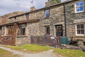 A stone building with multiple windows, a wooden fence, and a sign indicating a private area. - Mountain cottage in stunning location with outstanding views (Coniston)