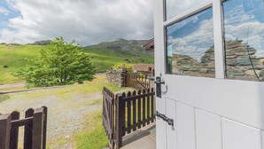 Un bâtiment blanc avec une porte en bois et un mur en pierre.