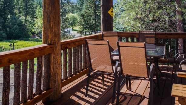 A wooden deck with a view of a mountainous landscape. - Martin City Log Cabin, just a hop away from Glacier National Park (Martin City)