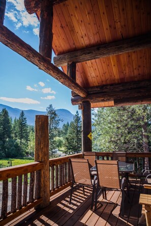 Une terrasse en bois offrant une vue sur un paysage montagneux.