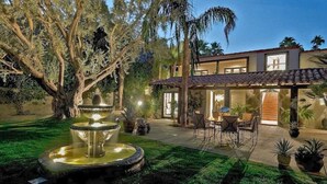 Une maison moderne dotée d’un patio, d’une fontaine et d’un espace repas.