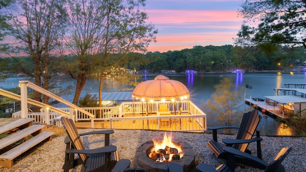 A lakeside deck with outdoor seating, a fire pit, and a gazebo. - AMAZING COVE! 3 Bed/2Ba Lakefront Home - Hot Tub, Smart TVs, EV Charger, Firepit (Eldon)