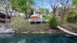 A riverside property with a deck and a gazebo. - AMAZING COVE! 3 Bed/2Ba Lakefront Home - Hot Tub, Smart TVs, EV Charger, Firepit (Eldon)