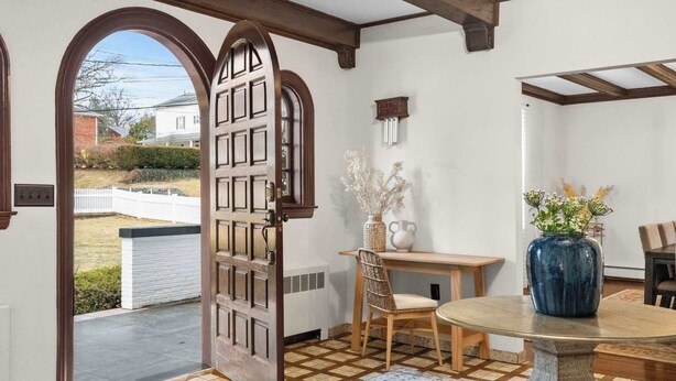 A room with a wooden door, a small table with a vase, and a chair. - Spacious 3b/3b Mediterranean in White Plains (White Plains)