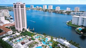 A high-rise hotel with a pool area, waterfront views, and a marina.