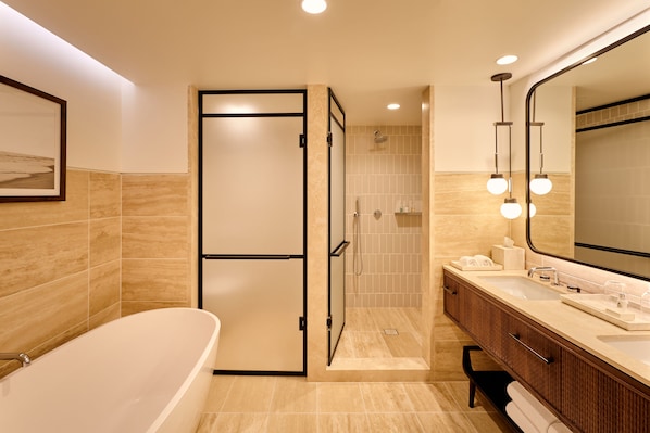 A modern bathroom with a freestanding bathtub, a walk-in shower, and a vanity with a large mirror.