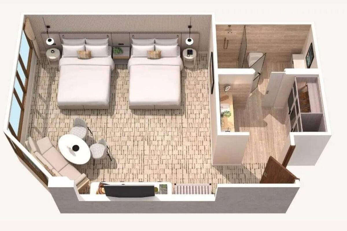 A modern hotel room with two beds, a small seating area, and a bathroom.
