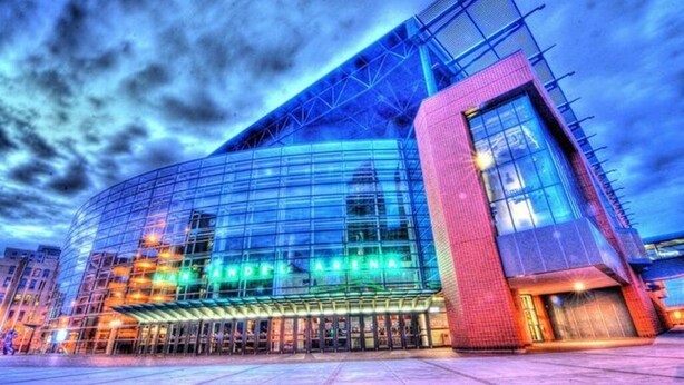 A modern hotel with a curved glass facade and a prominent entrance. - GR Retreat - 2BR, Mins from Downtown & Restaurants, Nintendo Switch & Games  (Grand Rapids)