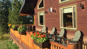 A wooden deck with outdoor seating and flower planters.
