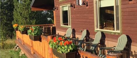 A wooden deck with outdoor seating and flower planters.