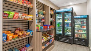 Un rayon dédié aux en-cas, avec divers types de chips et de produits salés, ainsi que deux réfrigérateurs pour les boissons.
