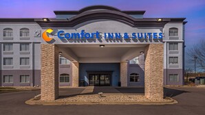 Un bâtiment de la chaîne Comfort Inn & Suites, doté d’une entrée moderne et surplombant un ciel dégagé.