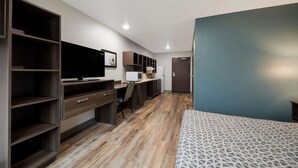 Een moderne slaapkamer met een bed, een bureau en een kledingkast.