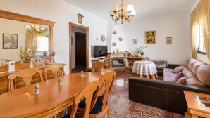 Un comedor con mesa y sillas de madera, un sofá y una chimenea.