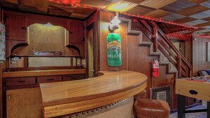 A bar area with wooden furniture, a Sierra Nevada Pale Ale sign, and a staircase. - Dunsmuir Adventure House ~ Spacious family getaway (Dunsmuir)
