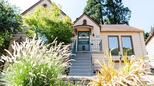 A two-story house with a welcoming entrance, a front porch, and a staircase leading to the door. - Dunsmuir Adventure House ~ Spacious family getaway (Dunsmuir)