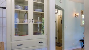 A kitchen with white cabinets, a tiled backsplash, and a wooden floor. - Dunsmuir Adventure House ~ Spacious family getaway (Dunsmuir)