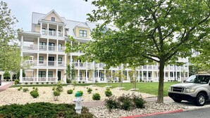 A multi-story hotel with a symmetrical facade, balconies, and a well-maintained lawn. - Beautiful Sunset Island 3 BR Condo, FREE Linens &Towels, includes 4 Beach Chairs (Ocean City)