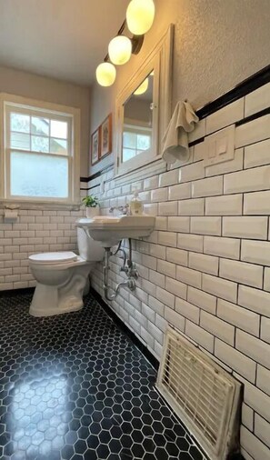 Ein Badezimmer mit Toilette, Waschbecken und Spiegel.