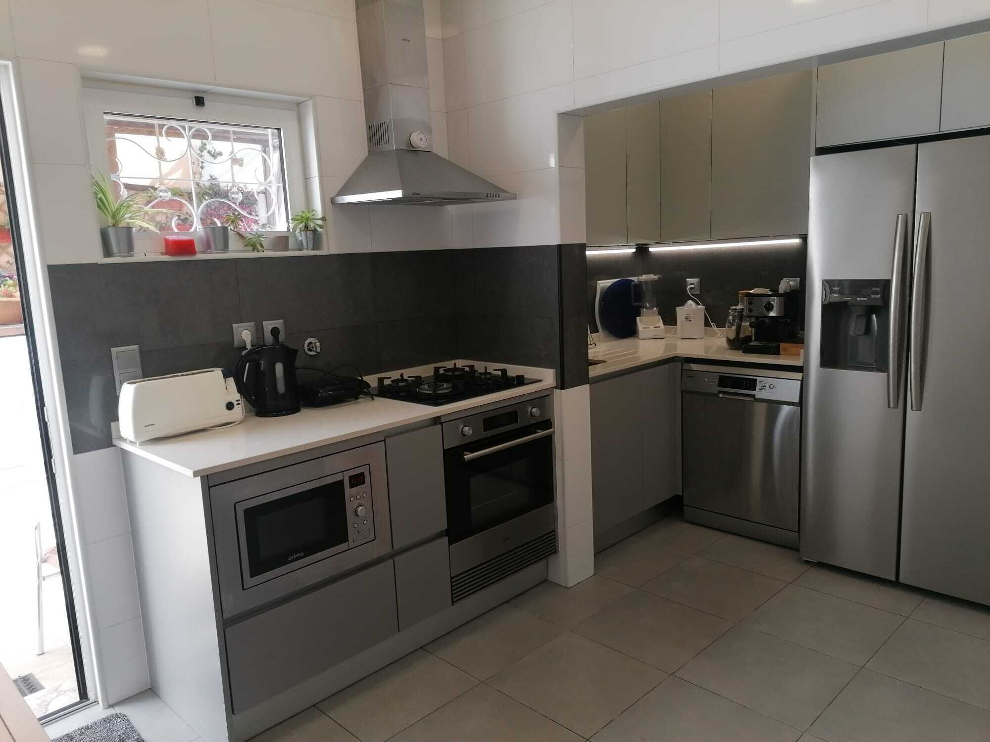 A modern kitchen with stainless steel appliances, a gas stove, an oven, and a built-in dishwasher.