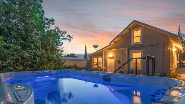 Ein Whirlpool vor einem Haus, im Hintergrund ein Sonnenuntergang.