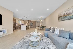 A modern living room with a sofa, coffee table, and artwork on the wall.