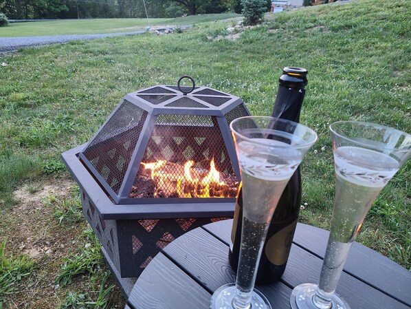 Un foyer hexagonal, avec une bouteille de champagne et deux verres posés sur une table en bois.