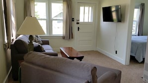Een kamer met een bank, een tafel, een televisie en een bed.