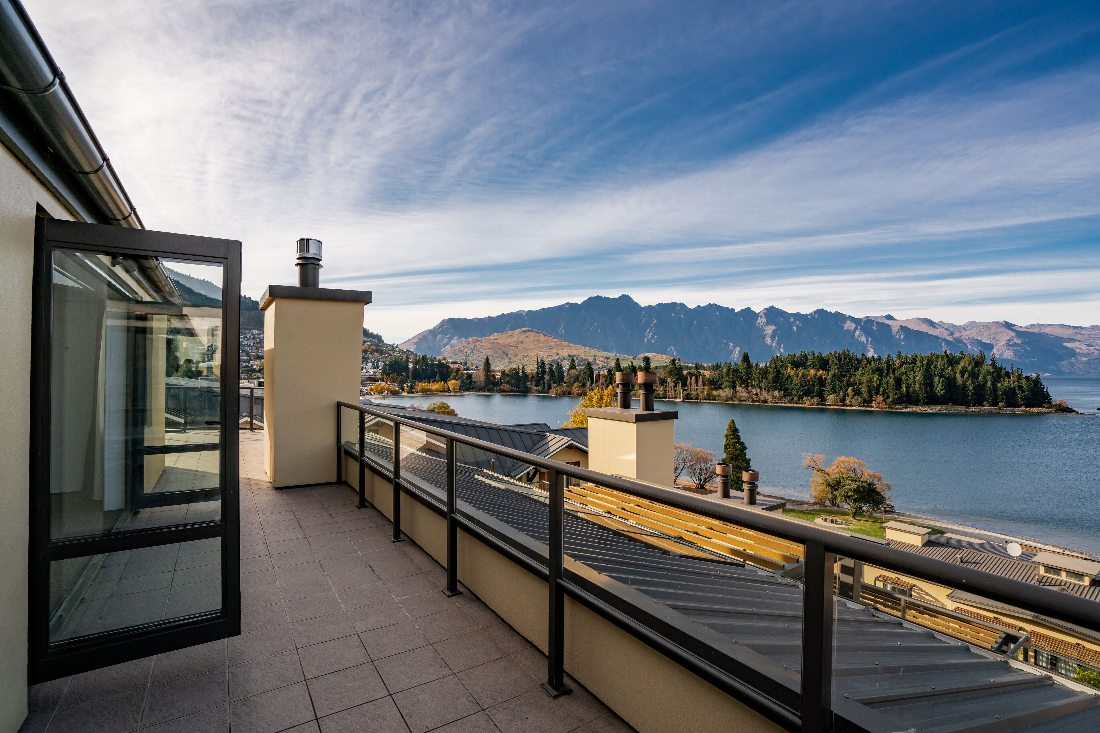 A balcony with a view of a lake and mountains.
