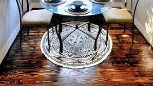 A dining area with a round table, four chairs, a patterned rug, and a window with blinds. - Dallas Fair Park 3B/2B Downtown Deep Ellum (Dallas)