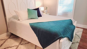 A neatly made bed with a white headboard, multiple pillows, and a teal blanket. - Dallas Fair Park 3B/2B Downtown Deep Ellum (Dallas)