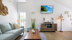A modern living room with a sofa, coffee table, TV, and decorative items. - Vacation at the most beautiful beaches (Panama City Beach)