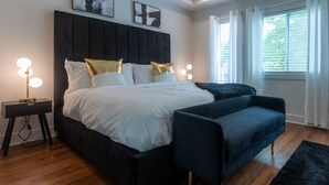 A modern bedroom with a large bed, bedside lamps, and artwork on the wall. - Five75 Lux ATL King Bed & Game Room Downtown (Atlanta)
