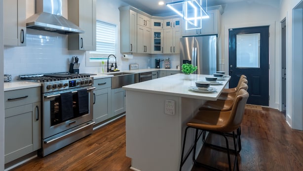 A modern kitchen with stainless steel appliances, a central island, and wooden flooring. - Five75 Lux ATL King Bed & Game Room Downtown (Atlanta)
