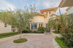 A courtyard with a stone pathway, a small tree, and a building with a tiled roof. - Villa Perdiz, Puerta del Sol | 4 Bed, 4 Bath (Cabo San Lucas)