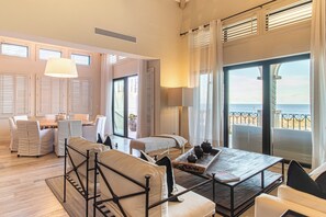 A spacious room with a large bed, a dining area, and a view of the sea. - Villa Perdiz, Puerta del Sol | 4 Bed, 4 Bath (Cabo San Lucas)