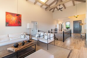 A spacious living area with a high ceiling, a white sofa set, a coffee table, and a painting on the wall. - Villa Perdiz, Puerta del Sol | 4 Bed, 4 Bath (Cabo San Lucas)